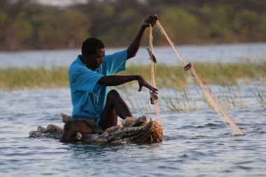 küçük teknesinde gün doğarken olta bogoria Gölü Milli Parkı Kenya'da bir adam