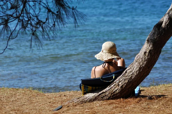 Dívka s kloboukem relaxaci na pláži — Stock fotografie