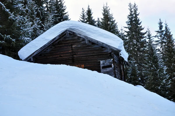 新鮮な雪で覆われている山の木造の小屋 — ストック写真