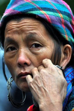 Flower Hmong woman with a silver earring. Sapa, Vietnam clipart