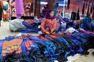 Woman from Black H'mong minority tribe selling textile in Bac Ha market, Vietnam clipart