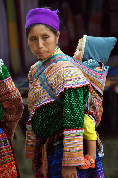 Hmong Frau trägt ihr Kind in bac ha, Vietnam — Stockfoto