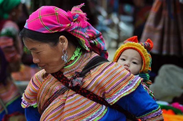 Hmong kobieta niosąca dziecko w bac ha, Wietnam — Zdjęcie stockowe