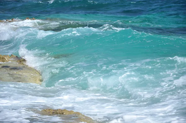 Ondas azuis batendo em uma costa — Fotografia de Stock