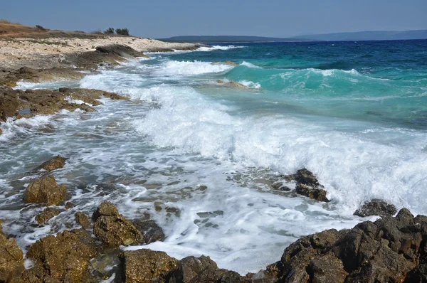 Onde blu che si infrangono su una battigia — Foto Stock