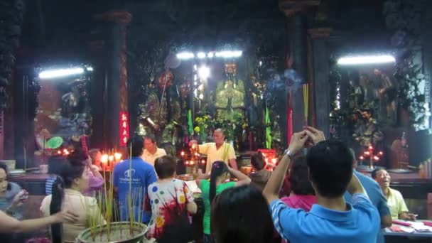 Niet-geïdentificeerde gelovigen bidden en het aanbieden van stokjes voedsel en wierook voor de goden in de vietnamese jade keizer pagode — Stockvideo