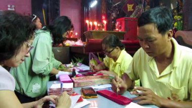 yaşlı kadın bir kağıt üzerinde Çince harfler yazmak