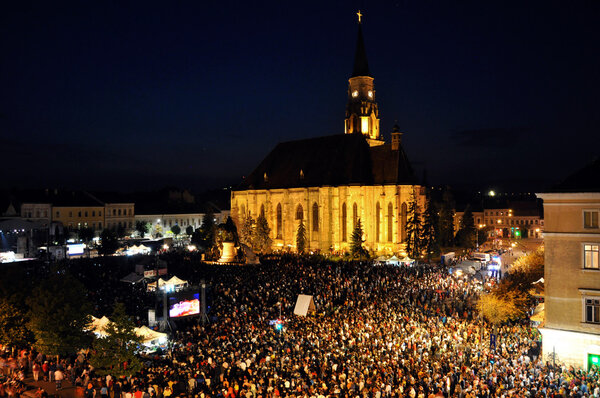Ten thousands of people, crowd in the main city square at evening, during a live concert