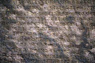 Background with ancient sanskrit text etched into a stone tablet clipart
