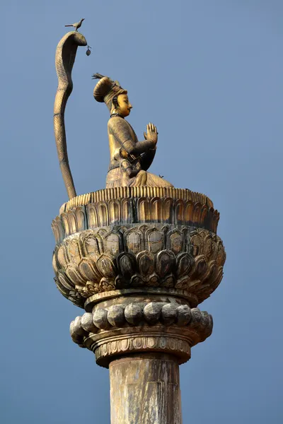 King Yoganarendra Malla bronze statue, under cobra snake, flanked by his wives, over stone column. Durbar square. Patan, Kathmandu, Nepal — Stock Photo, Image