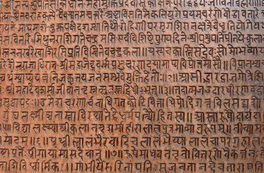 Background with ancient sanskrit text etched into a stone tablet clipart