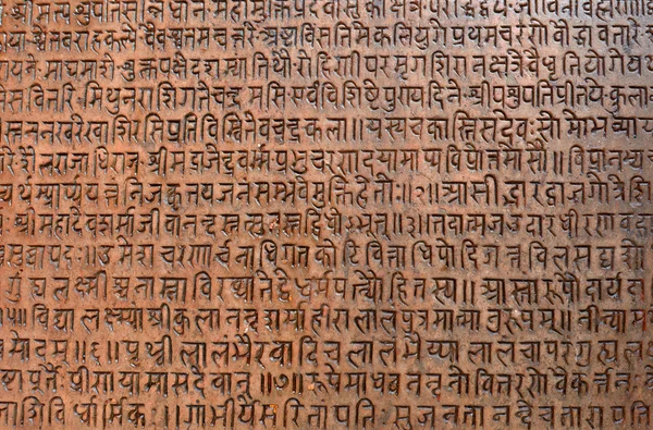 Arrière-plan avec du texte sanscrit ancien gravé dans une tablette de pierre — Photo
