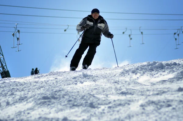 Skier skiing down the slope in a beautiful sunny day — Stock Photo, Image