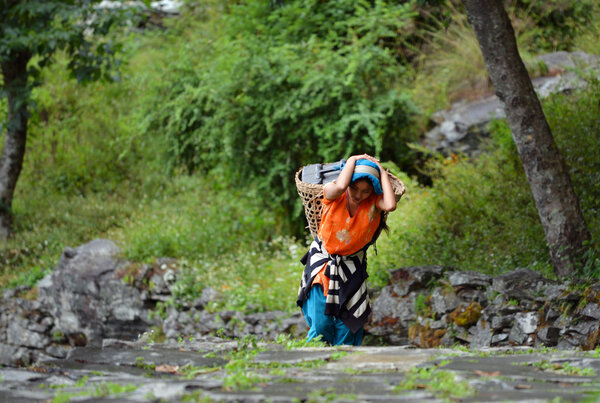 Молодая шерпа Гурунг, несущая корзину в Гималаях
