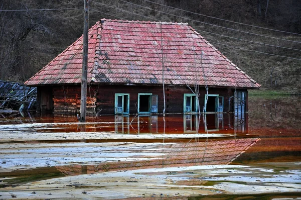 Opuszczony dom zalana zanieczyszczonej wody z miedzi odkrywkowych kopalni — Zdjęcie stockowe