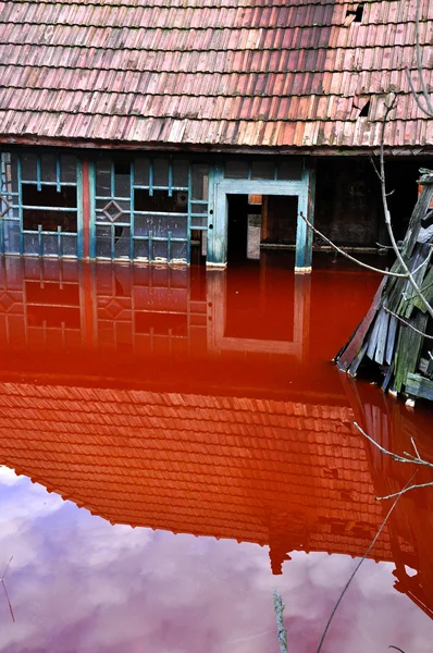 Uma casa abandonada inundada por água poluída de uma mina de cobre — Fotografia de Stock