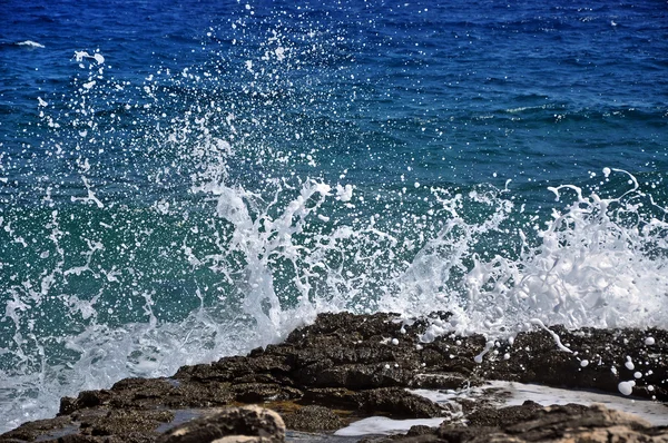 Mächtige Wellen brechen an felsigem Strand zusammen — Stockfoto