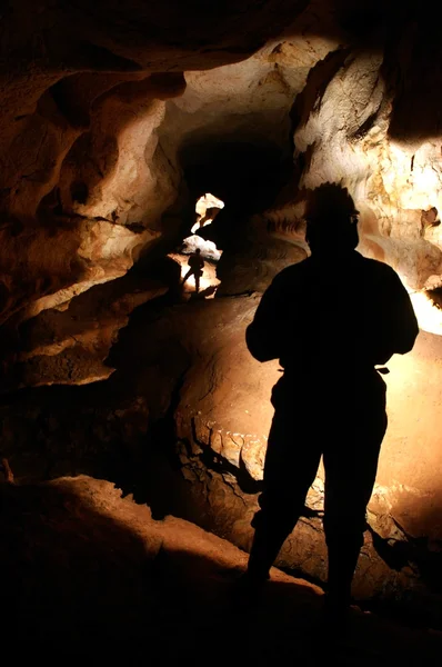Пещерный проход с исследователями пещер — стоковое фото
