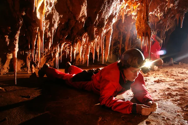 Paleontólogo estudiando fósiles en una cueva — Foto de Stock