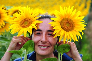 Ayçiçeği bir alanın ortasında güzel bir kadın