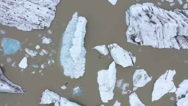 アイスランドのFjallsarlon氷河ラグーンの浮遊氷山の上を飛んでいます 地球温暖化と気候変動による氷冠の融解の空中像 — ストック動画