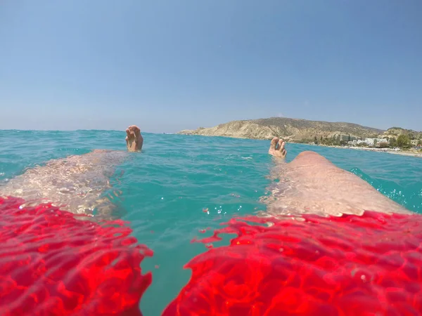 人在海水上漂浮 穿着红色泳衣在海里漂浮的游泳者的脚和腿 — 图库照片