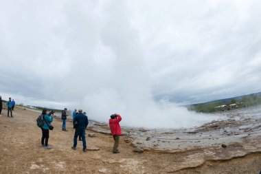 STROKKUR GEYSER, ICELAND - 20 Mayıs 2019: İzlanda Altın Çemberinde Strokkur gayzerinin patlamasını ziyaret eden ve bekleyen turistler