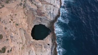 Above aerial view of Giola natural pool near the Mediterranean seaside. Waves crushing the shoreline. Thassos island, Greece