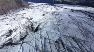 İzlanda 'daki Solheimajokull buzulunun hava görüntüsü. Crevasse ve buzun içinde yakalanan siyah volkanik kül. Küresel ısınma ve iklim değişikliği kavramı