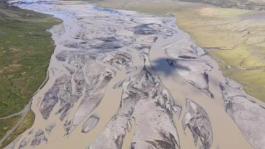 Kocaman bir nehir yatağının üzerinde uçuyor. Buzul nehir sistemi, İzlanda 'daki Vatnajokull buzulundan moraine tortuları taşıyor. Küresel ısınma ve iklim değişikliği çevre kavramı