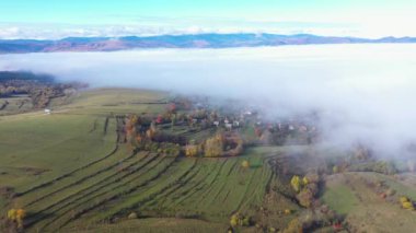 Aerial view of autumn clouds above countryside pasture. Flying over hills with drone