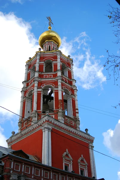 Bell tower of High-Petrovskiy monastery in Moscow, Russia, on blue sky background