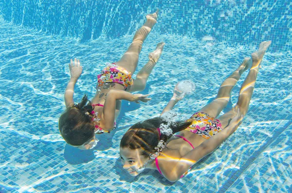 Happy smiling underwater children in swimming pool — Stock Photo, Image