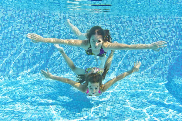 Feliz familia sonriente bajo el agua en la piscina — Foto de Stock