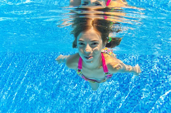 Feliz niño sonriente bajo el agua en la piscina — Foto de Stock