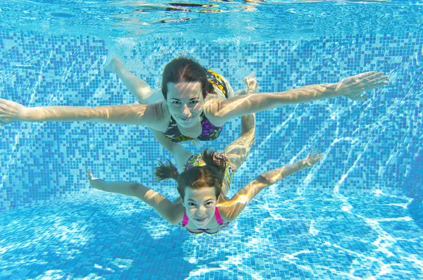 Feliz familia sonriente bajo el agua en la piscina —  Fotos de Stock