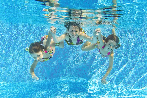Feliz familia sonriente bajo el agua en la piscina — Foto de Stock
