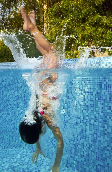 Happy smiling underwater child in swimming pool