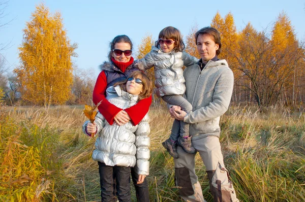 Familia feliz de cuatro en el parque de otoño — Foto de Stock