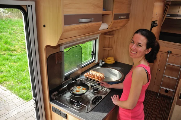 Woman cooking in camper Stock Image