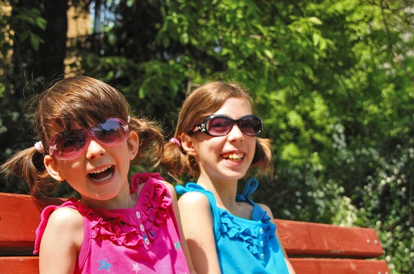 Duas crianças sorridentes se divertindo ao ar livre, irmãs brincando — Fotografia de Stock