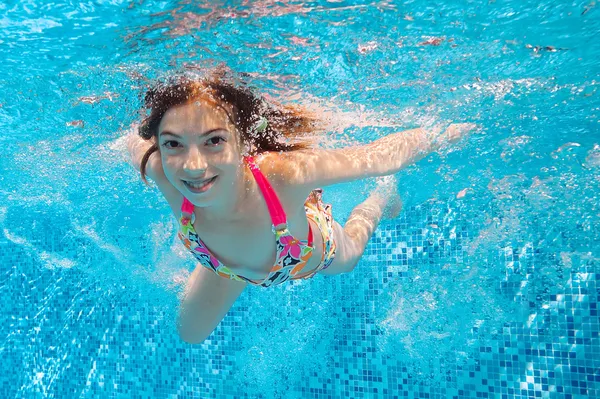 Feliz chica bajo el agua nada en la piscina —  Fotos de Stock