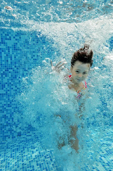 Feliz chica bajo el agua nada en la piscina — Foto de Stock