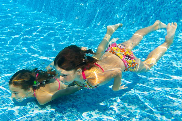 Crianças nadam debaixo d 'água na piscina — Fotografia de Stock