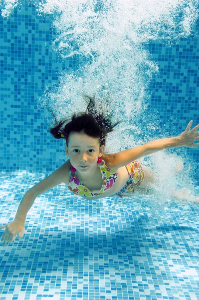 Little girl swims underwater in pool — Stock Photo, Image