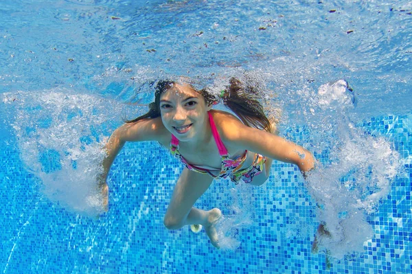 Glückliches aktives Kind schwimmt unter Wasser im Pool — Stockfoto