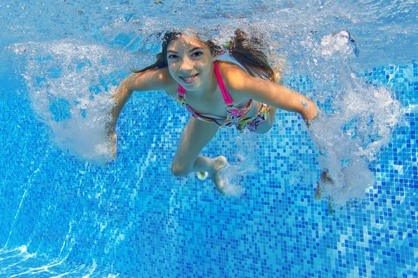 Criança ativa feliz nada debaixo d 'água na piscina — Fotografia de Stock