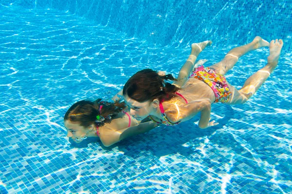 Crianças nadam debaixo d 'água na piscina — Fotografia de Stock