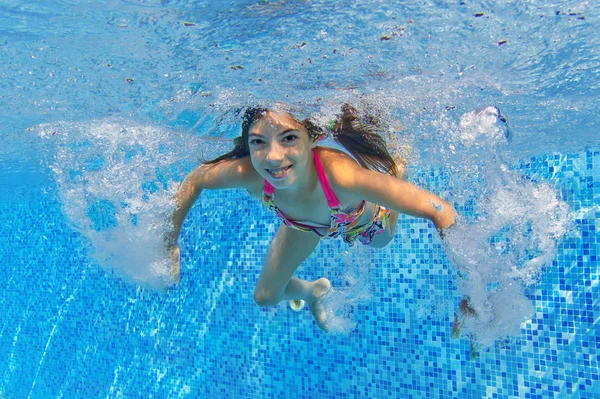 Glückliches aktives Kind schwimmt unter Wasser im Pool — Stockfoto