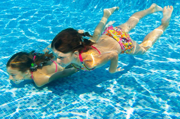 Niños nadan bajo el agua en la piscina — Foto de Stock